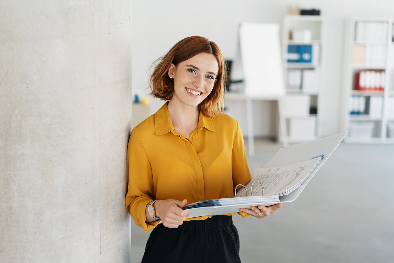 Attractive,Young,Office,Worker,Holding,A,Large,Open,Binder,As